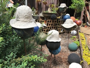 Cement encrusted hats rest on bowling ball hat stands